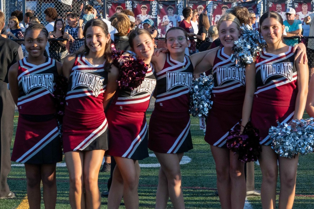 Cheerleaders stand arm in arm