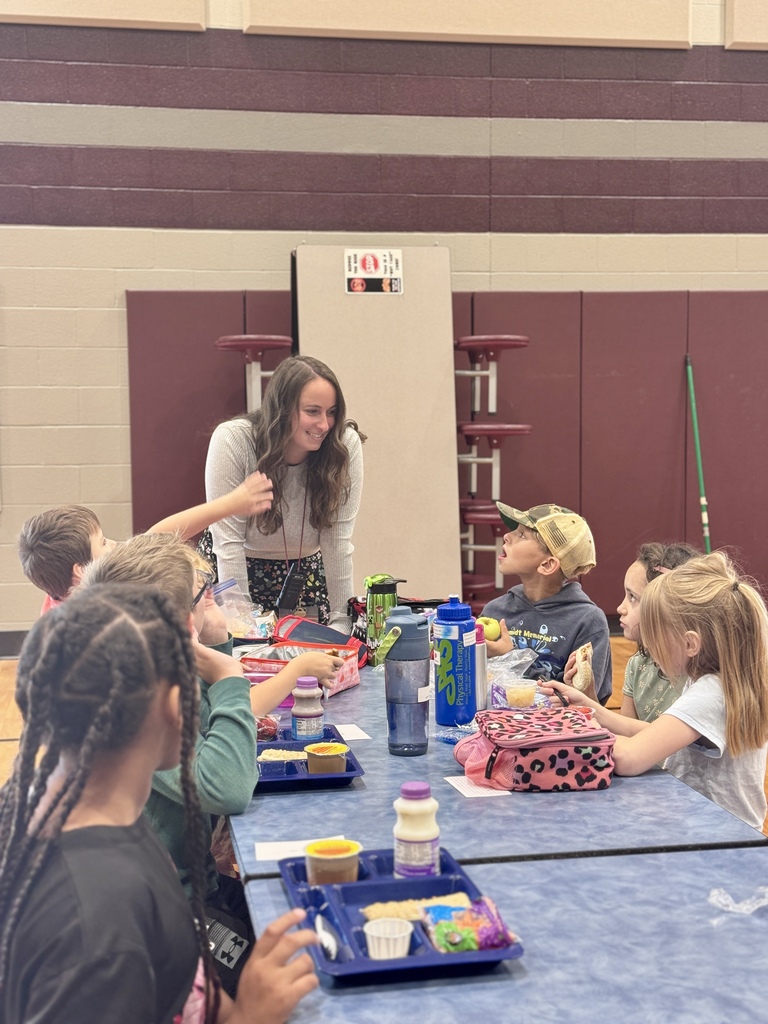A staff member connects with students over lunch.