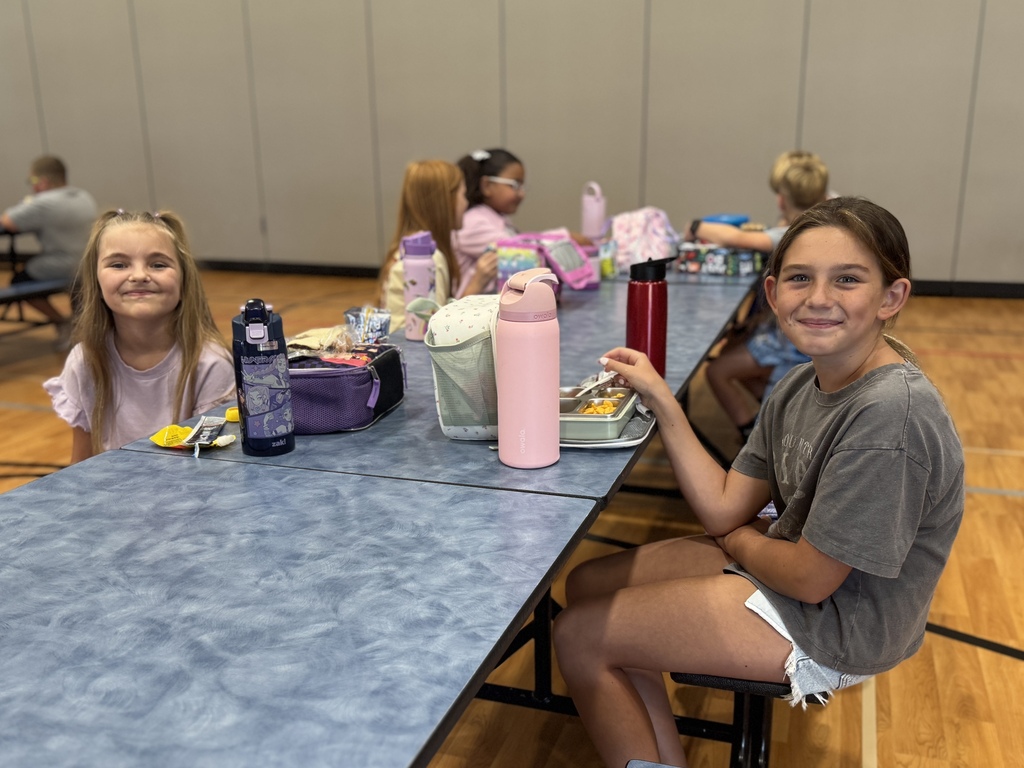 Students smile together at lunch.