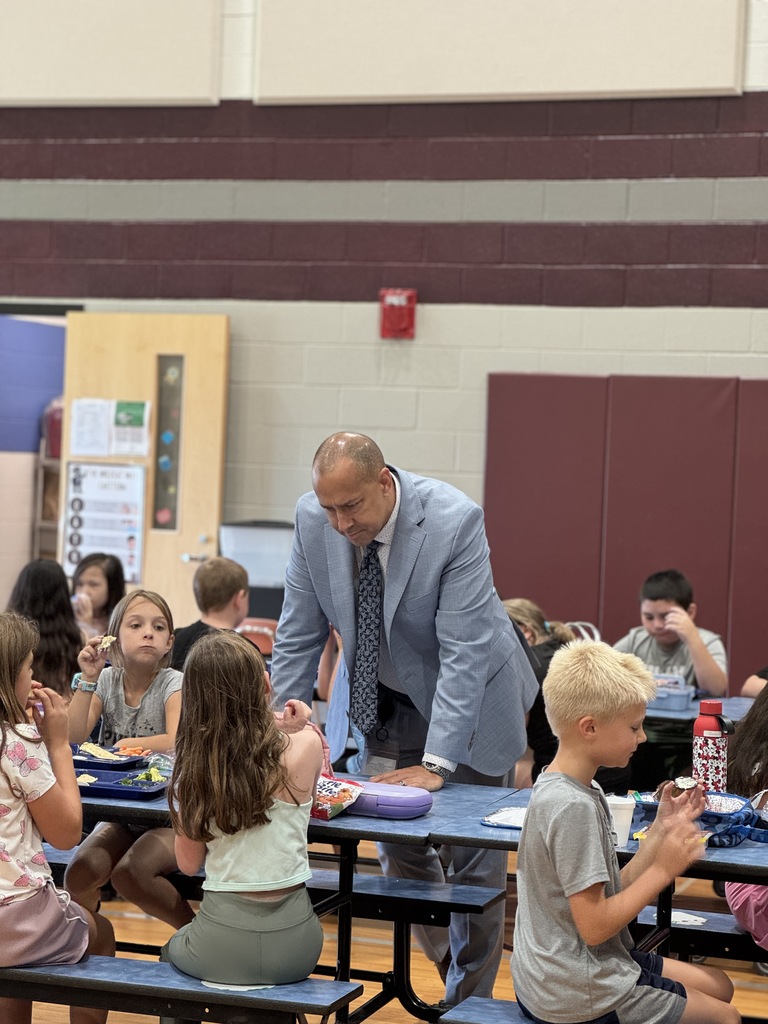 A building principal connects with students over lunch.