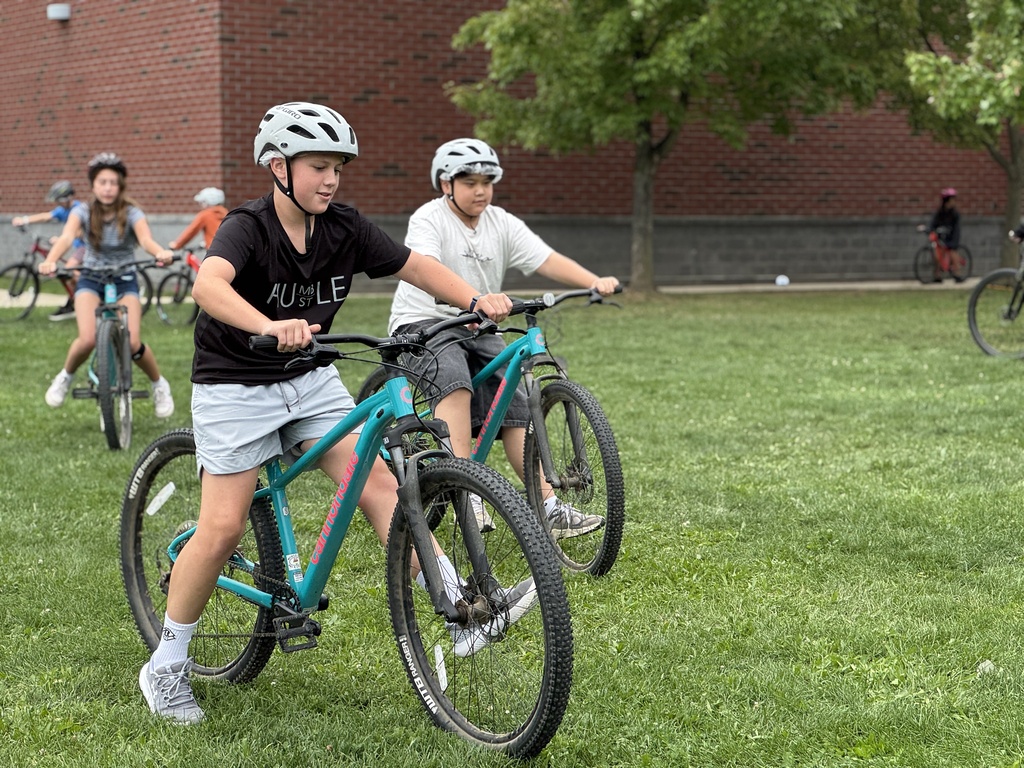 Students learn striding on a bike.