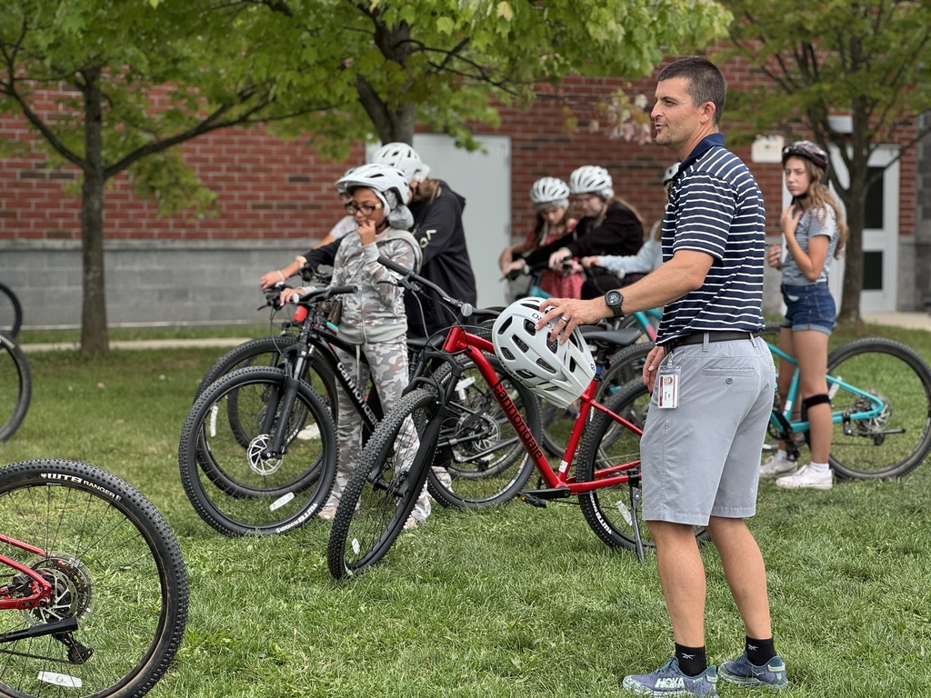 A teacher gives a bike riding lesson.