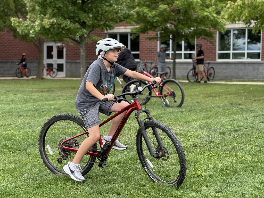 Students learn striding on a bike.