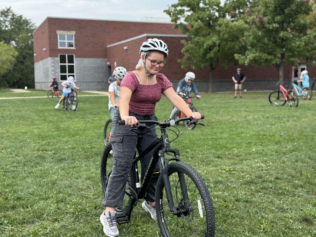 Students learn striding on a bike.