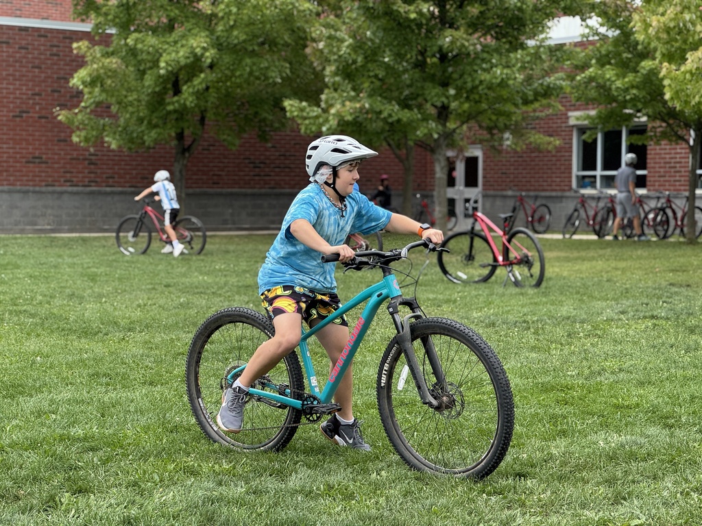 Students learn striding on a bike.