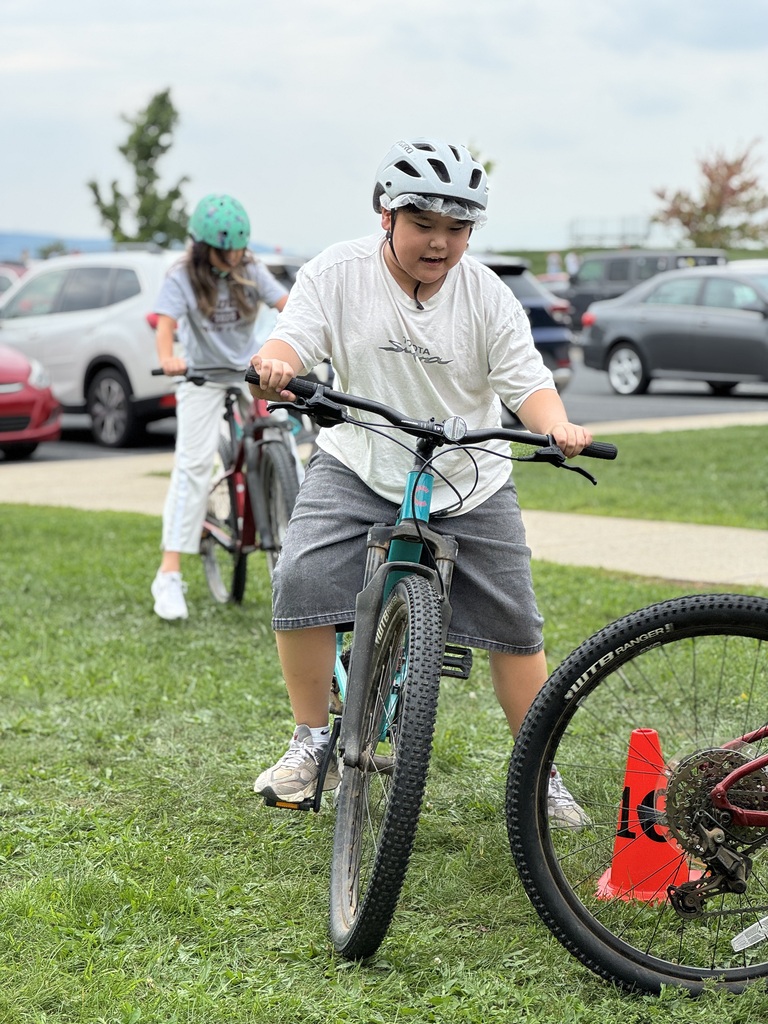 Students learn striding on a bike.