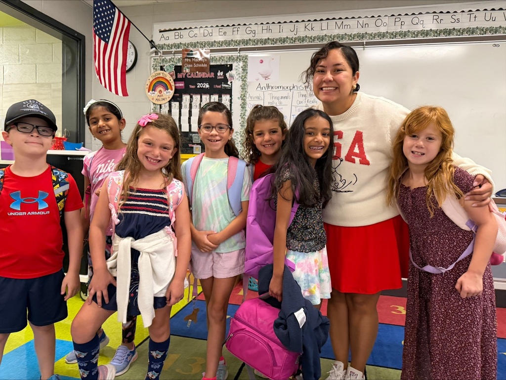 A teacher and her students wear red, white, and blue.