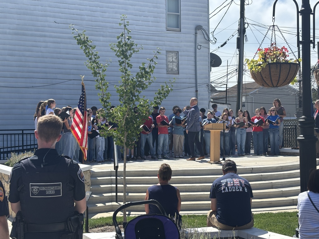Students sing on stage while first responders watch.