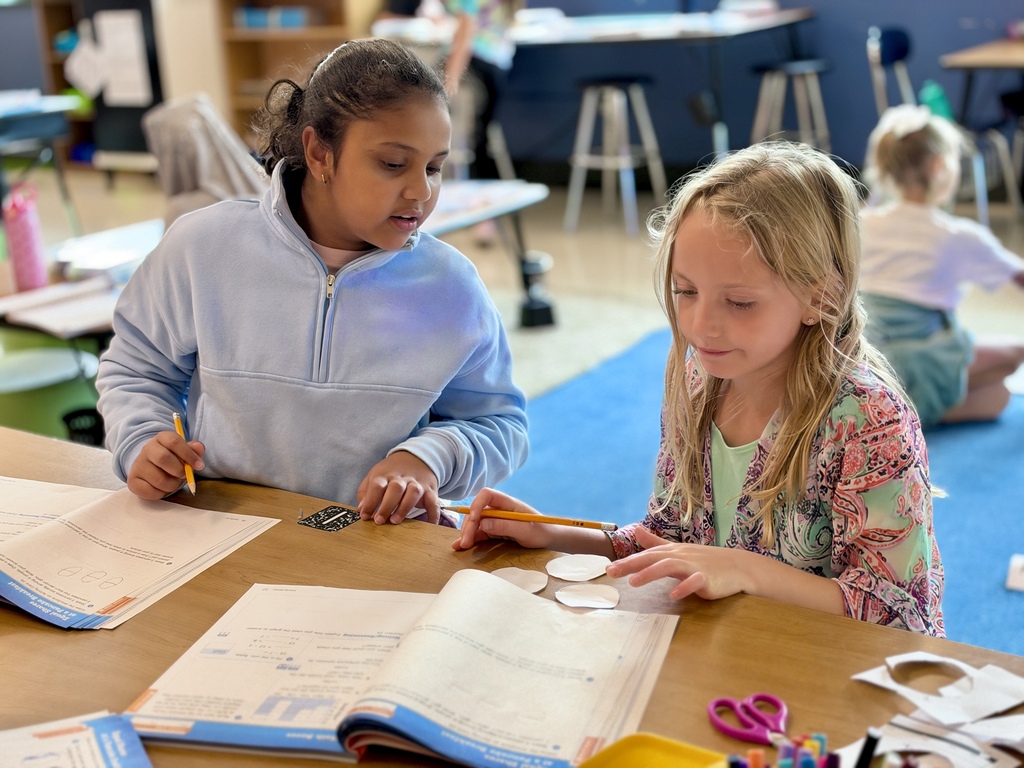 Two young students work on a math assignment together.