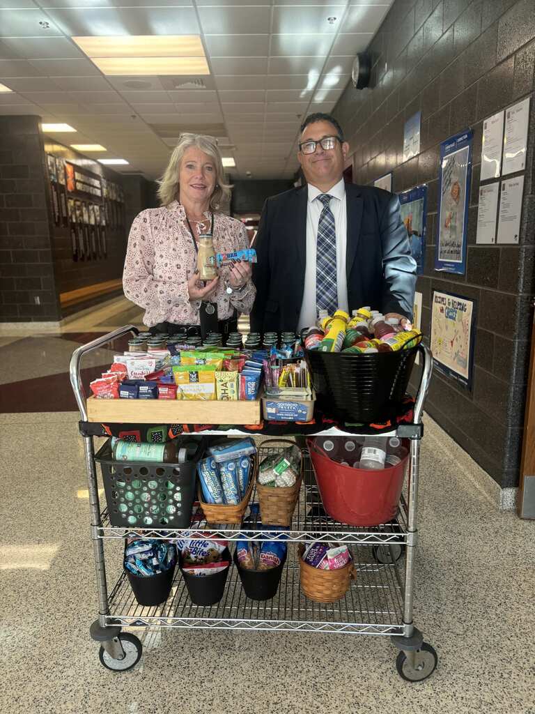 Two principals prepare to deliver snacks to staff in a school.