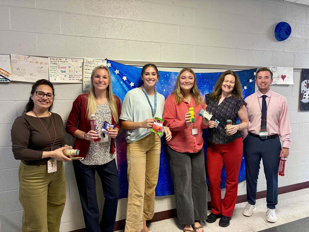 Staff show off the snacks they picked from the snack cart.