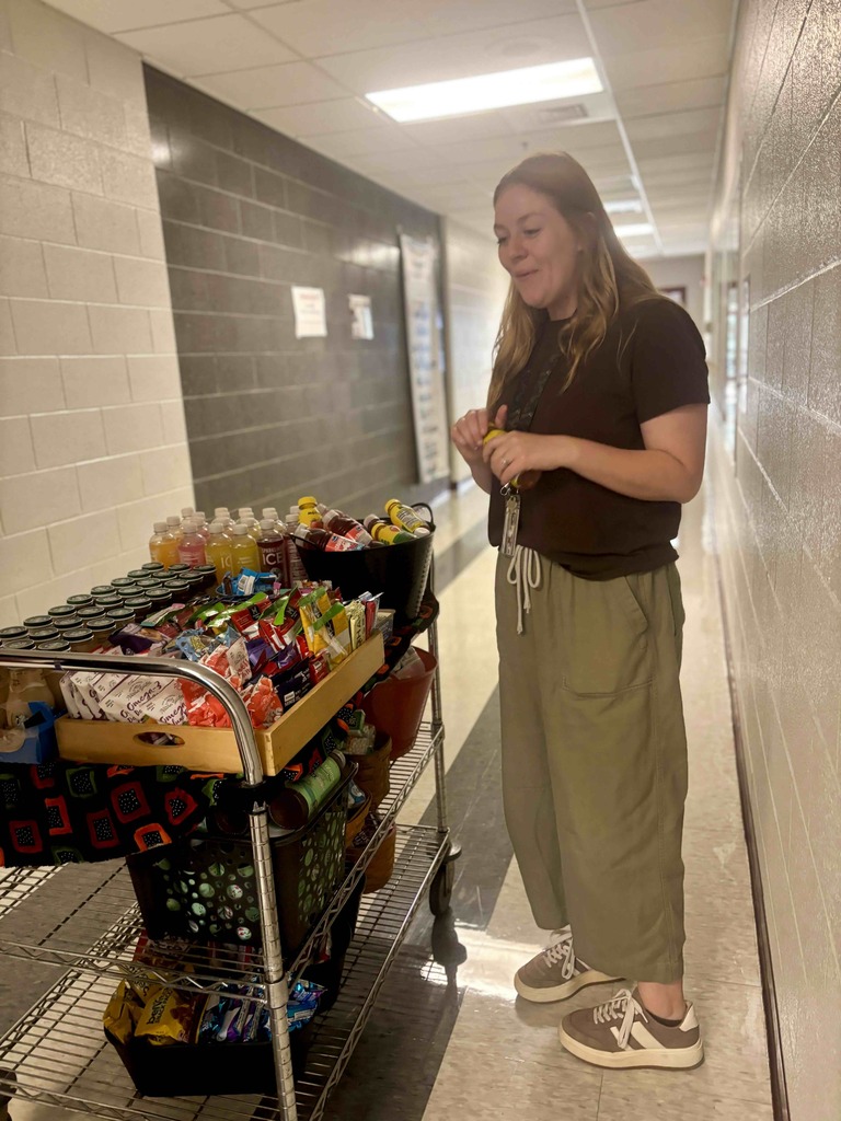 A teacher pics a snack from a snack cart.