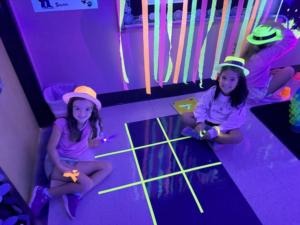 Students play glow in the dark tic tac toe.