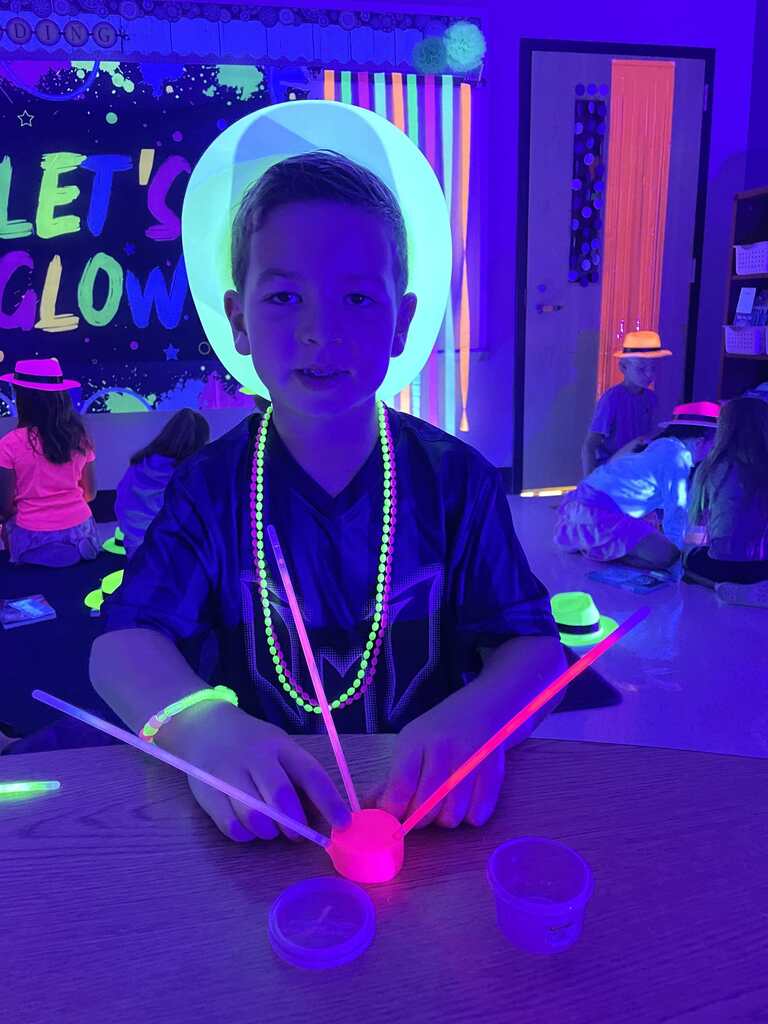 Students play glow in the dark games in a classroom.