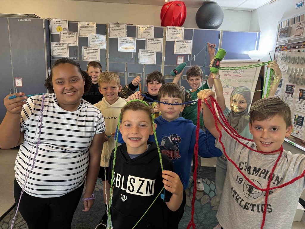 Students are wrapped in yarn during a crochet lesson.