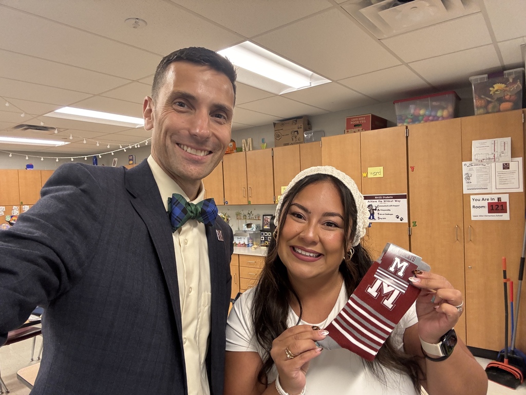 A man takes a selfie of him and a lady who is holding a pair of branded M socks.