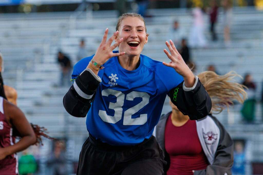A field hockey goalie celebrates a win.