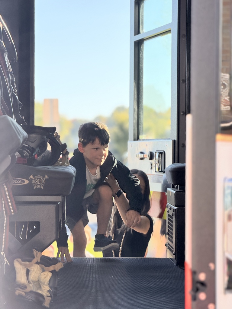 A young student climbs into a fire truck.