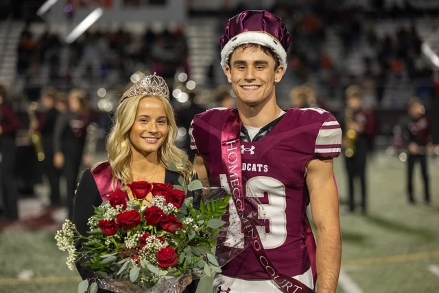 A homecoming king and queen pose for a picture.
