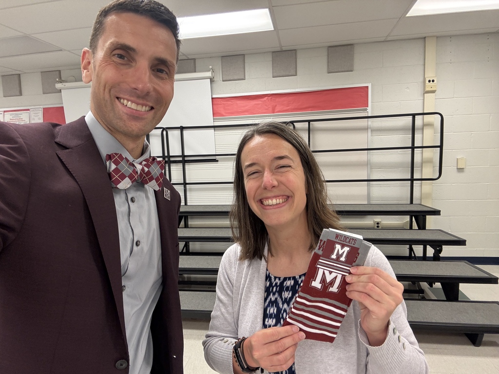 A man presents a staff member with a pair of branded M socks.