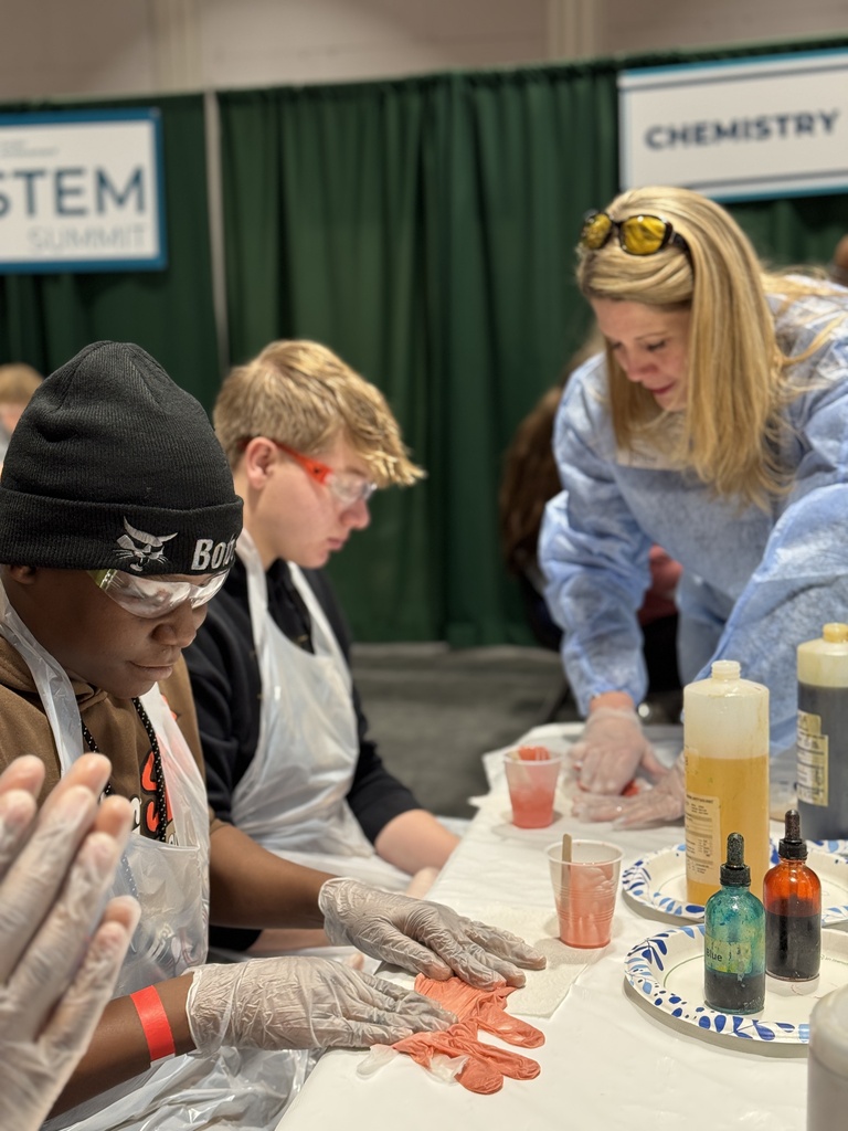 Students participate in a hands on science project at a table.