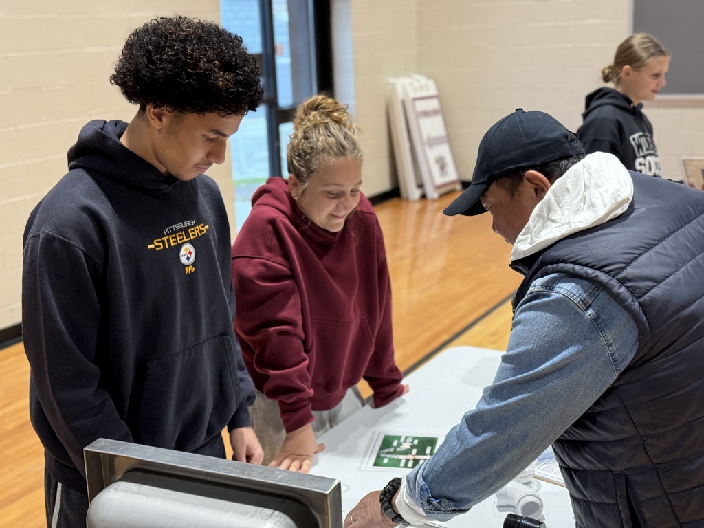 Students work together at a table on a science project.