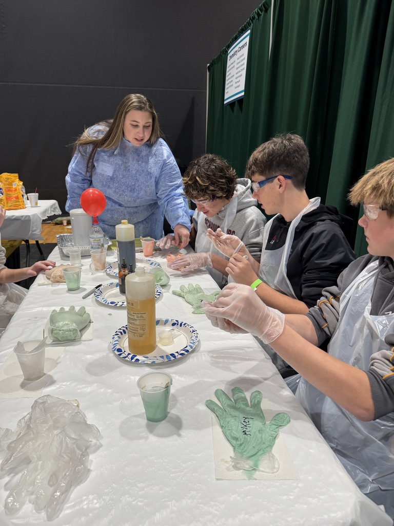 Students complete a hands on science project while sitting together at a table.