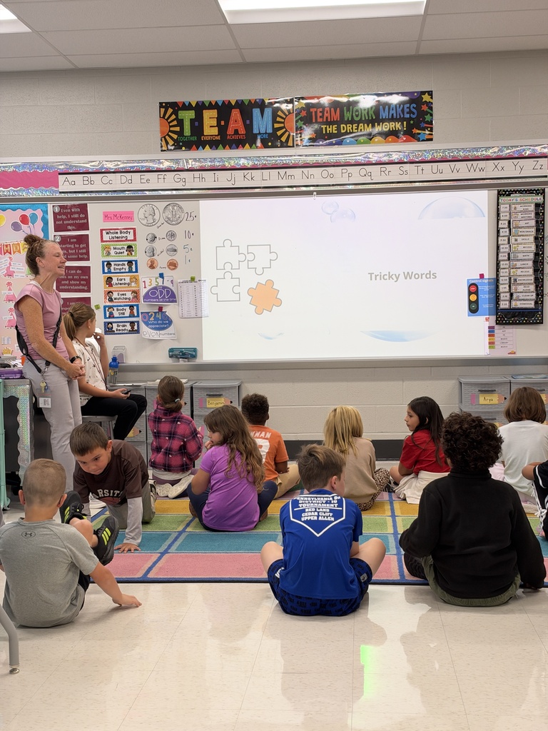 Students sit on a classroom floor to learn about tricky words.
