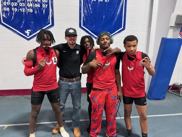 The Phoenix Boys 4x200 team, Tamon Mayo, Adrian Johnson, Devin Taylor, and Isaiah Osborne, posing with their medals and assistant coach Jacob Scott McQuain.