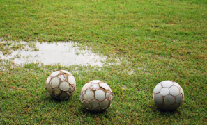 Soccer balls on soccer field with standing water