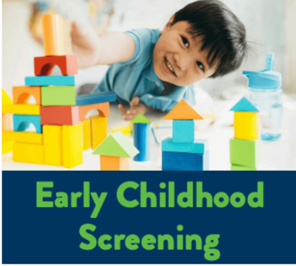 boy in blue shirt and dark hair playing with blocks