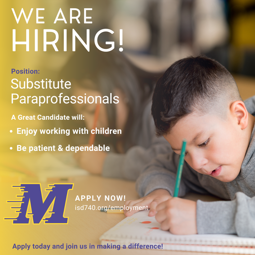 boy with brown hair and a grey sweatshirt and a blue pen writing in a notebook