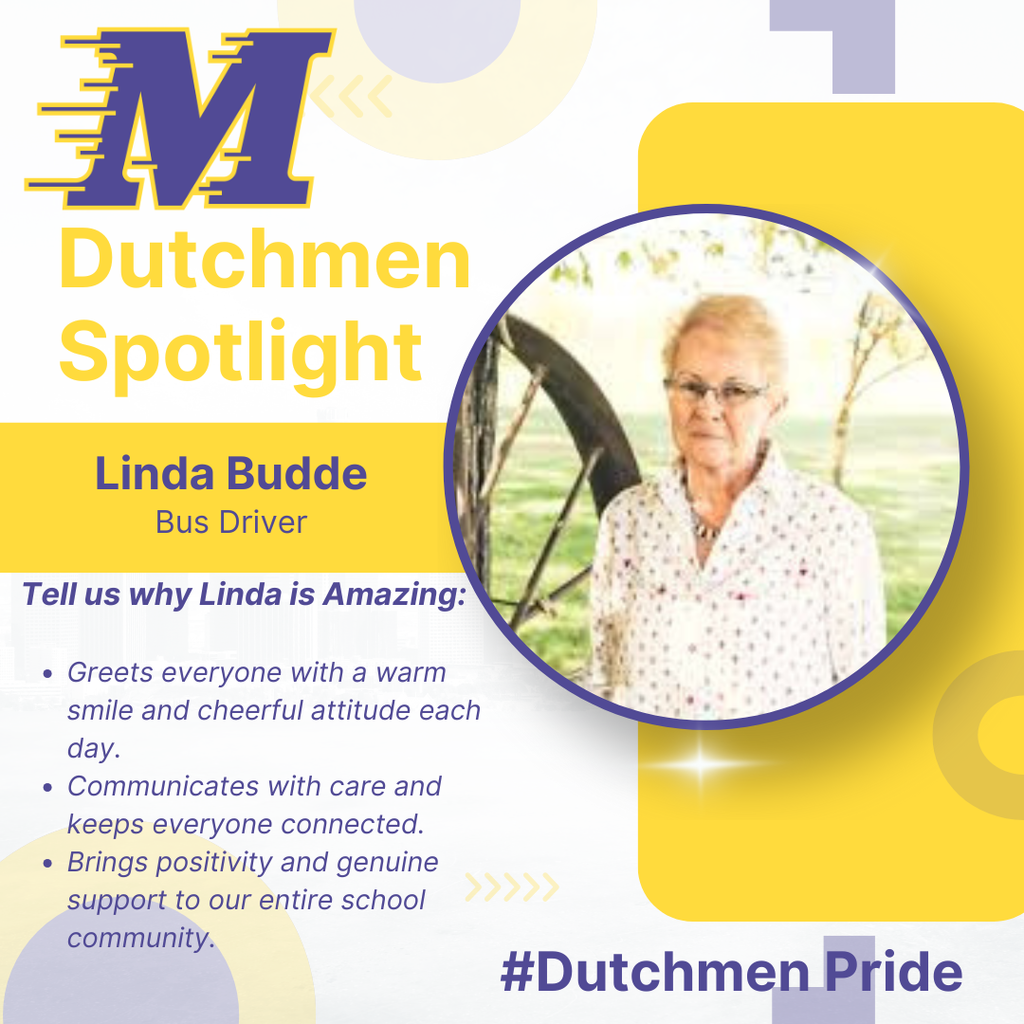 woman standing outside with an old wagon wheel with a patterned shirt, red hair and glasses