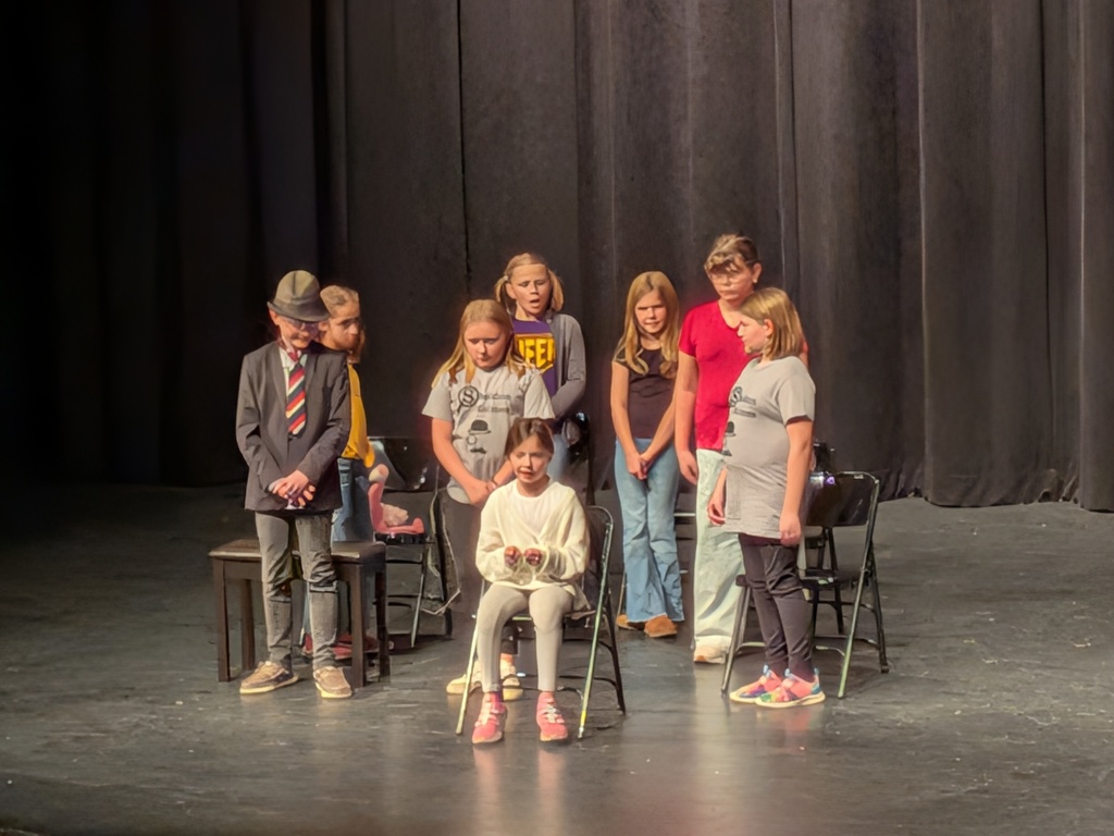 Group of kids standing in front of folding chairs