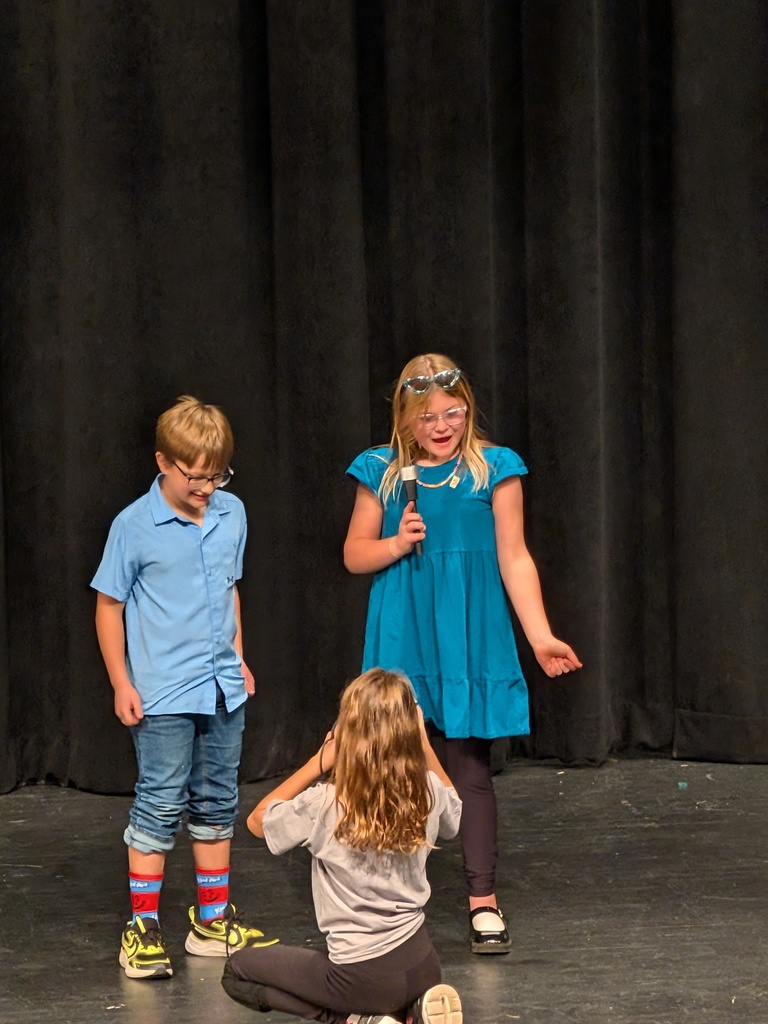 boy in blue shirt and jeans and red and blue socks and girl in blue dress with sunglasses on her head