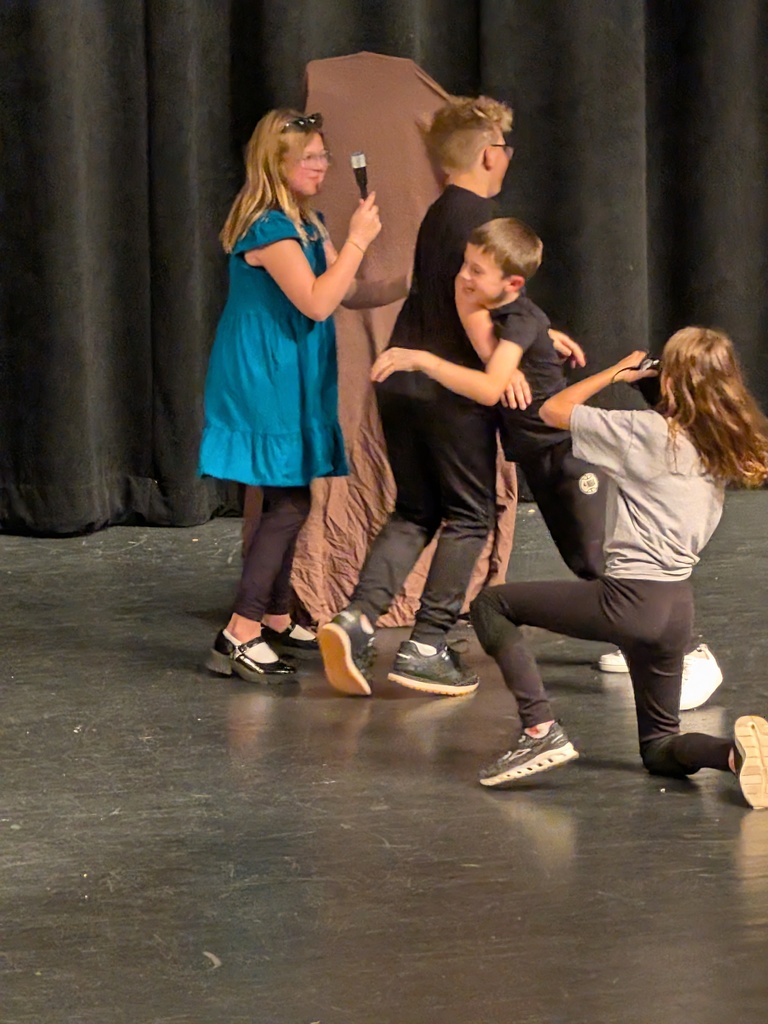 boys in black colliding, girl taking pictures 