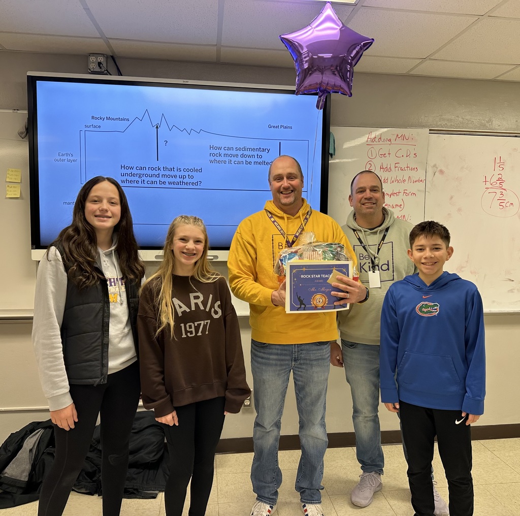 3 middle school kids, 1 teacher holding a cetificate, purple balloon and a gift bassket and one pricipal in front of a smart board