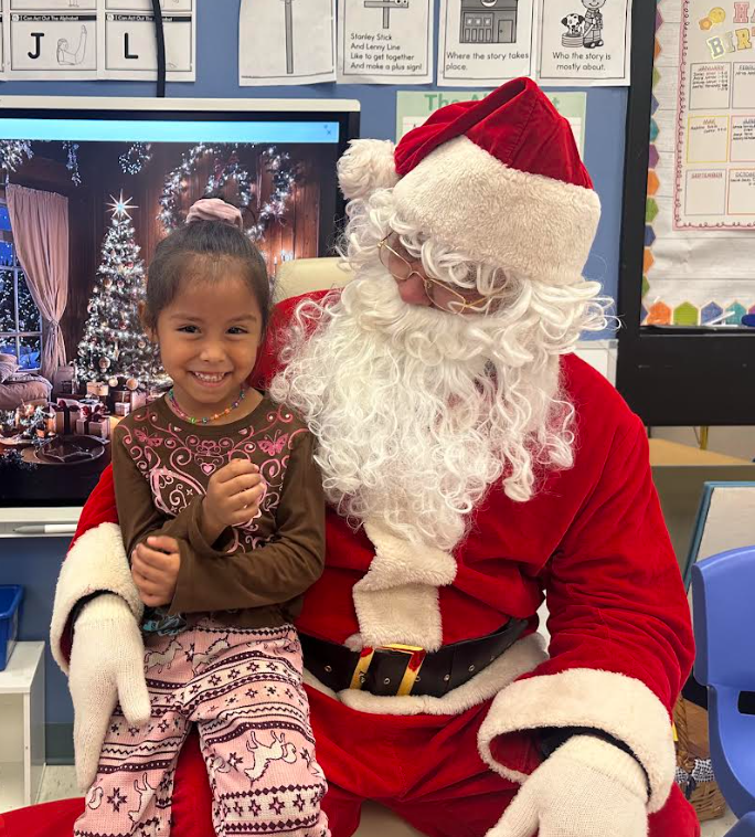 girl sitting on santa's lap and santa looking at the girl