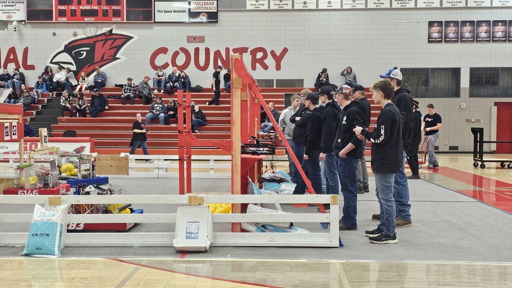 Boys wearing black shirts and Jeans driving a robot