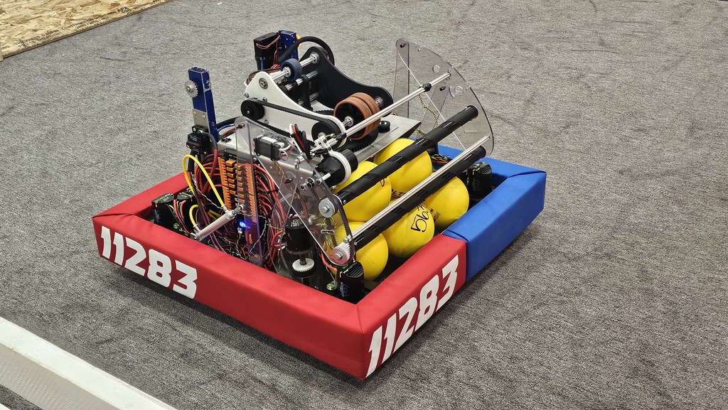 Robot with red and blue bumpers with balls in it