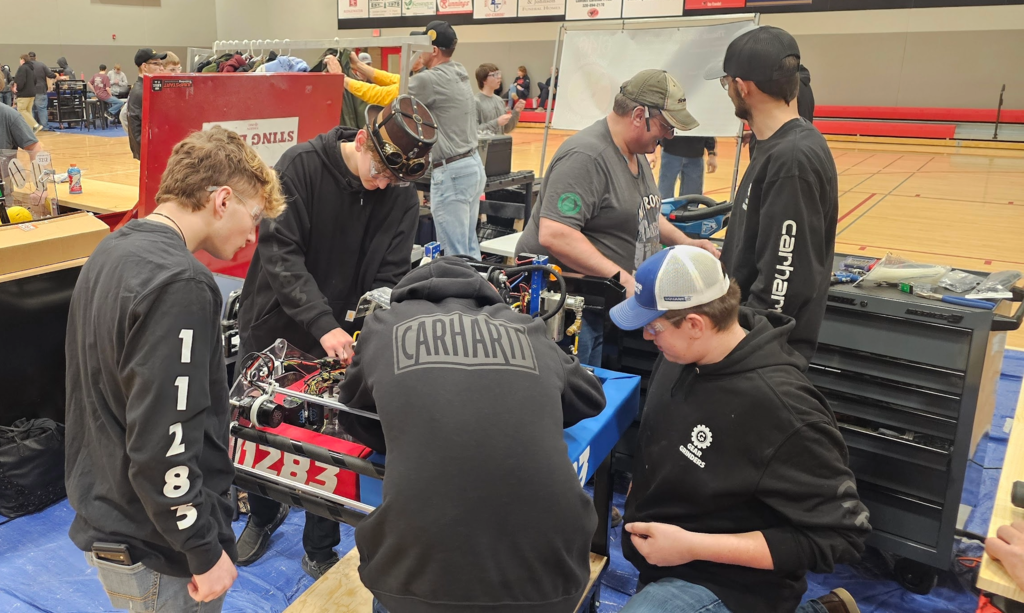Group of boys working on a First Robot with black shirts 