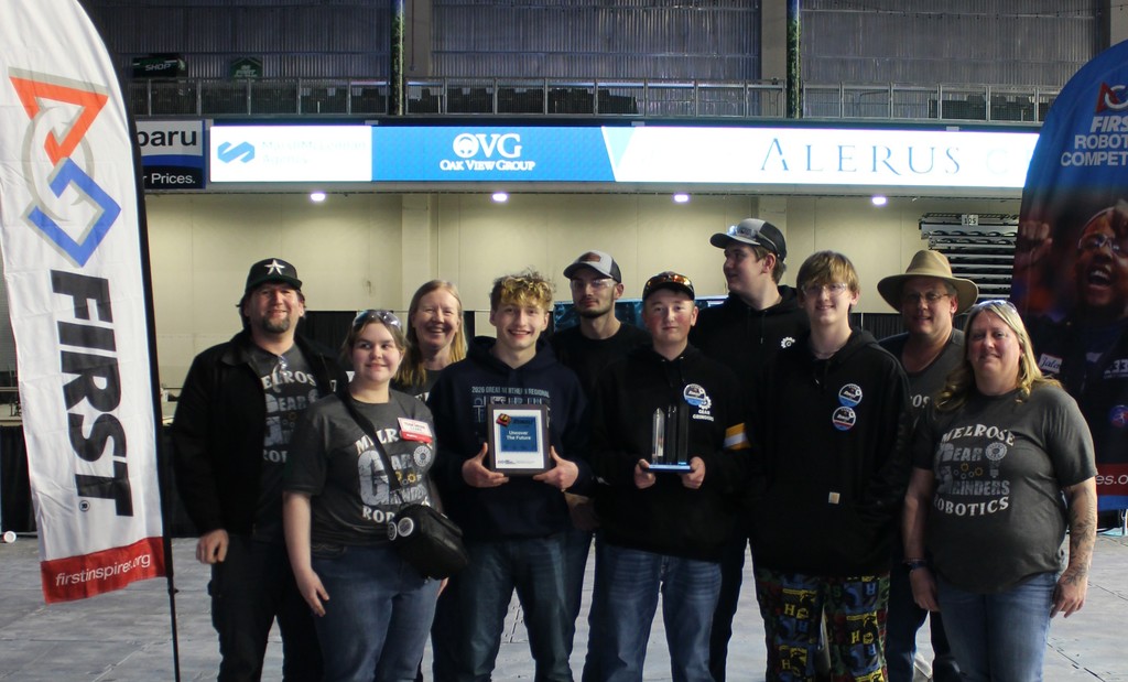 group of people standing by a first flag hold a trophy and a plaque.