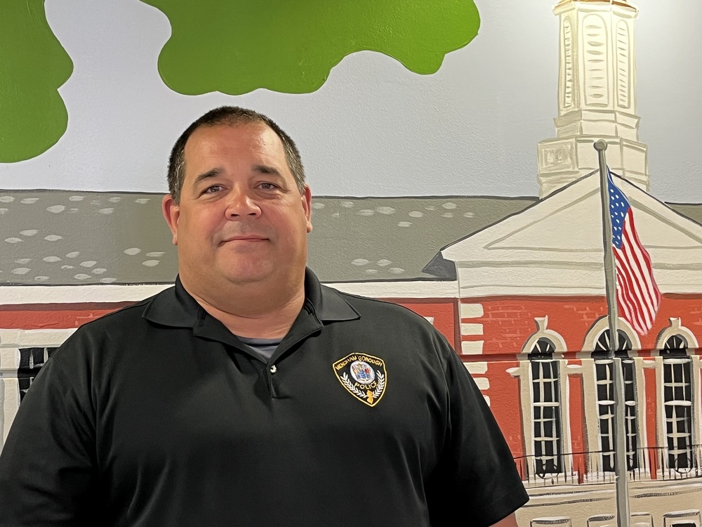 Officer Wysokowski in front of Hilltop School mural