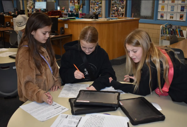 Photo shows students in the Pacific Intermediate library learning nonfiction text features 