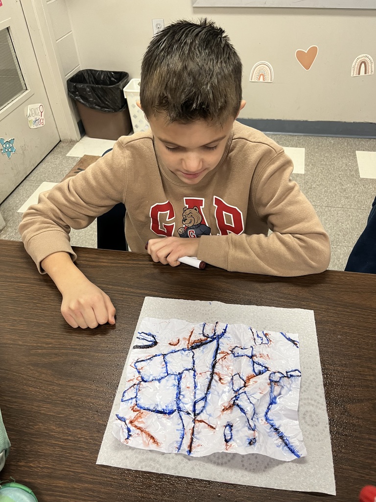 The photo shows Pacific Intermediate 5th graders learning about erosion with a hands-on activity