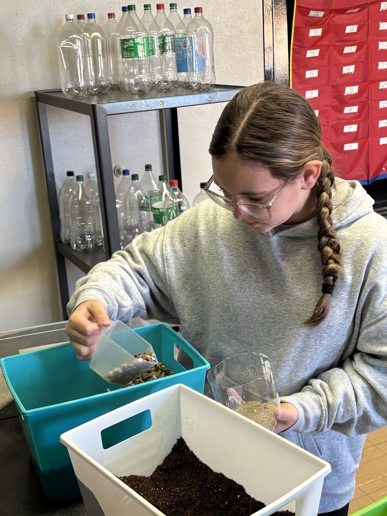 Students building sealed terrariums to model the water cycle.