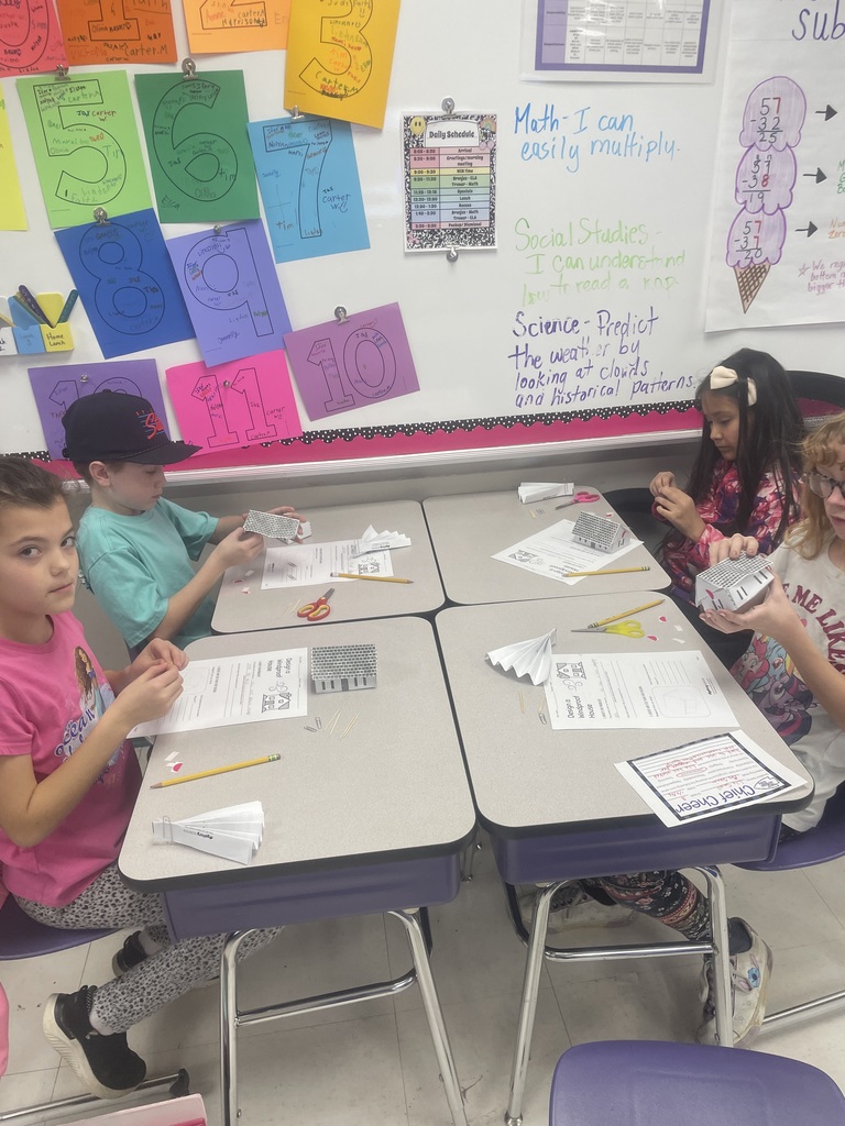 Students building paper houses. 