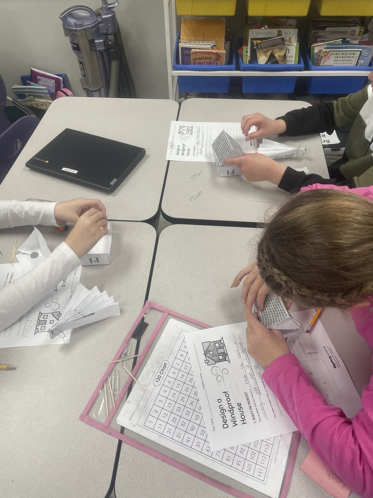 Students building paper houses. 