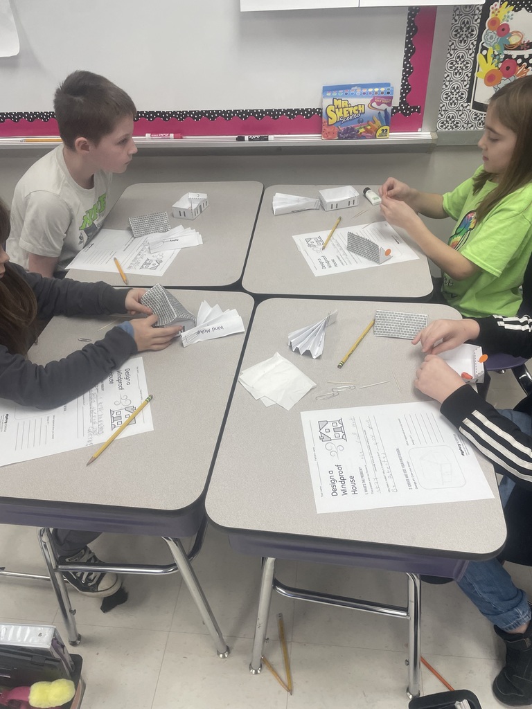 Students building paper houses. 