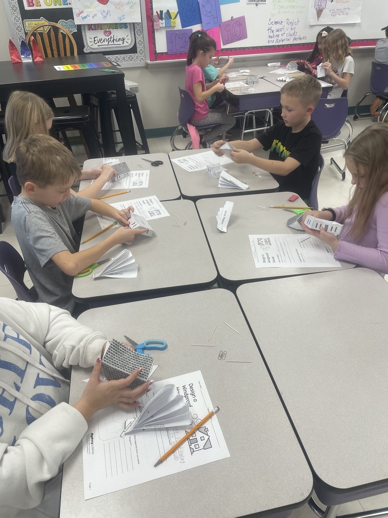 Students building paper houses. 